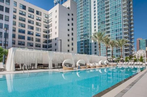 a large swimming pool with lounge chairs and buildings at Luxurious Highrise 2b 2b Apartment Heart Of Downtown LA in Los Angeles
