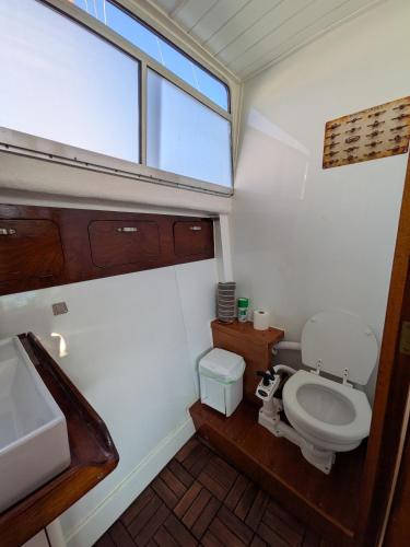 a bathroom with a toilet and a sink and a window at Over the Sea in Barcelona