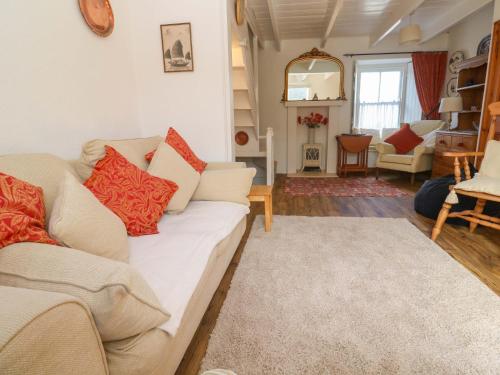 a living room with a white couch and red pillows at St Dominic Cottage in St Ives