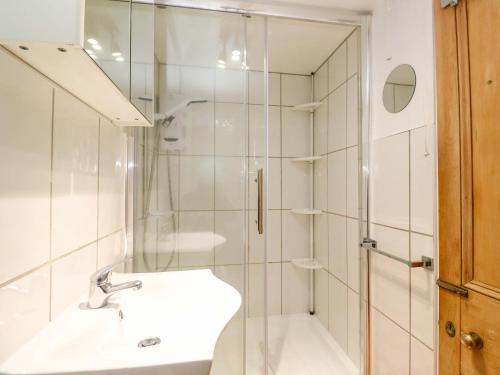 a white bathroom with a sink and a shower at St Dominic Cottage in St Ives