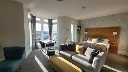 a living room with a couch and a bed at Harmony Apartments in Weston-super-Mare