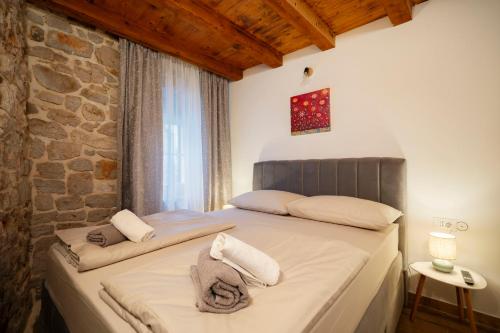 a bedroom with a bed with towels on it at Stone House Dida Toni Tribunj in Tribunj