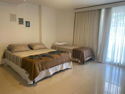 a bedroom with two beds and a window at 101 - Saint Sebastian Flat in Jaraguá do Sul