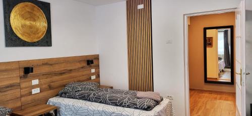 a bedroom with a bed and a wooden headboard at Pension Casa Leone in Timişoara