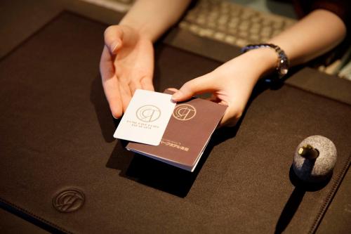 a person holding a card on top of a table at Royal Park Hotel Takamatsu in Takamatsu