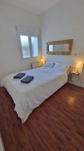 a large white bed with two towels on top of it at Apartamento Gaztelugatxe in Bakio