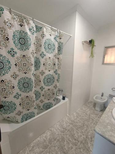 a bathroom with a shower curtain and a toilet at Sevilla Gateway a 10 min Sevilla y cerca aeropuerto, 3 habitaciones, 2 camas en cada habitación y sofá cama in Alcalá de Guadaira