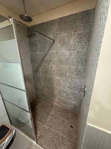 a shower with a glass door in a bathroom at Samarah E 01 full Sea View and adult pool prime location with garden , in Al Baḩḩāth