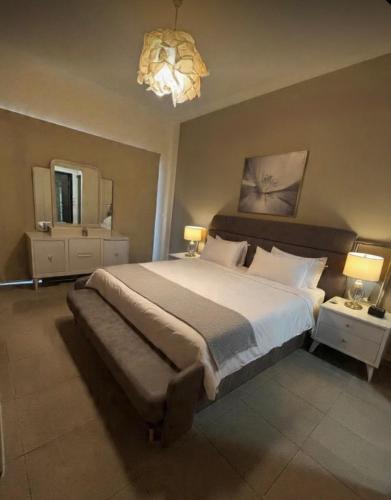 a bedroom with a large bed and a chandelier at Samarah E 01 full Sea View and adult pool prime location with garden , in Al Baḩḩāth