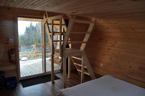 uma escada de madeira numa sala com um quarto em The ZzzzMoose 2.0 em Birch Plain