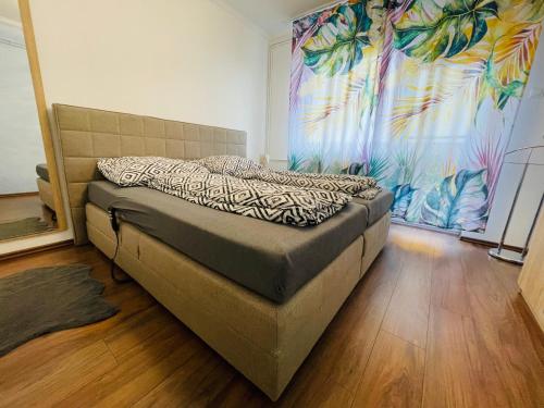 a bed in a room with a painting on the wall at Malaika Apartman in Sátoraljaújhely