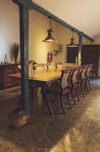 a wooden table and chairs in a room at Catumaran Jaffna in Jaffna