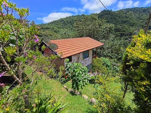 a house with an orange roof on a mountain at Sonho na Serra Chalé 1 in Gonçalves