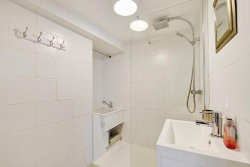 a white bathroom with a sink and a shower at 3 Bed in Croyde oc-2ingle in Croyde