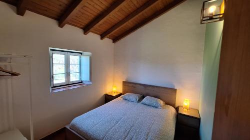 a bedroom with a bed with two lights on it at Monte Sardão in Cavaleiro