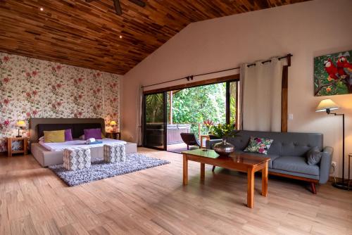 a living room with a bed and a couch and a table at Corcovado Nature Homes-Villas-Pool-Jacuzzi-Great Views in Puerto Jiménez