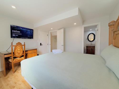a bedroom with a white bed and a tv on the wall at Cozy Rooms in Bright Walkout Suite - Newly Renovated in 2026 in Richmond Hill
