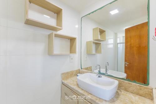 a bathroom with a sink and a mirror at Condominium w/ pool and steps fr/ the beach - SRCs in Ilhéus
