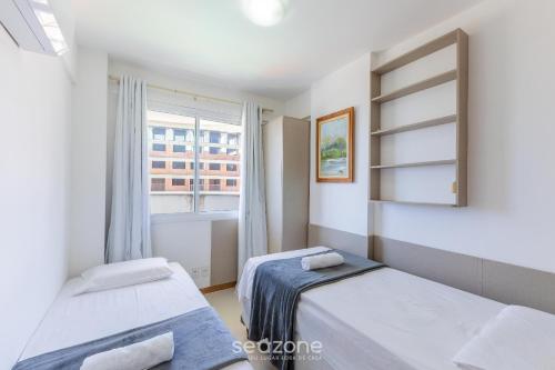 a bedroom with two beds and a window at Condominium w/ pool and steps fr/ the beach - SRCs in Ilhéus