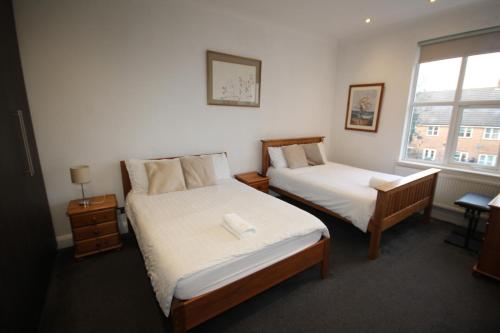 a bedroom with two beds and a window at Isleworth Apt C in Hounslow