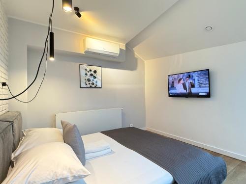 a bedroom with a bed and a tv on the wall at MINT Luxury Apartments at the Main Square in Krakow
