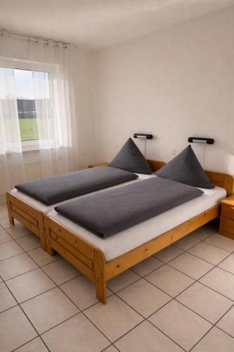 a wooden bed with two pillows on it in a room at Frühstückspension Stenbrock in Grevenbroich