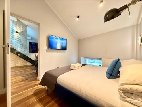 a bedroom with a bed and a tv on the wall at MINT Luxury Apartments at the Main Square in Krakow