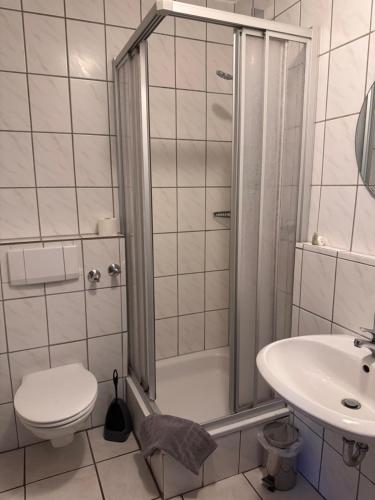 a bathroom with a shower and a toilet and a sink at Frühstückspension Stenbrock in Grevenbroich