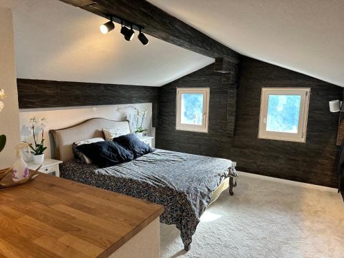 a bedroom with a bed and two windows at La Rose d Eva in Saint-Martin