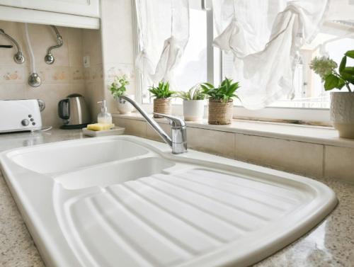 a white sink in a kitchen with potted plants at Apartamento Oásis Parque 2 in Portimão
