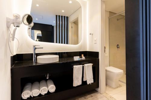 a bathroom with a sink and a mirror at Taua Hotel e Convention Alexania in Alexânia
