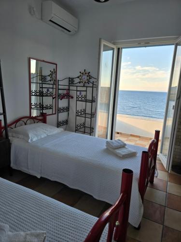 a bedroom with two beds and a view of the ocean at ADMIRAL'S VILLA in Loutra