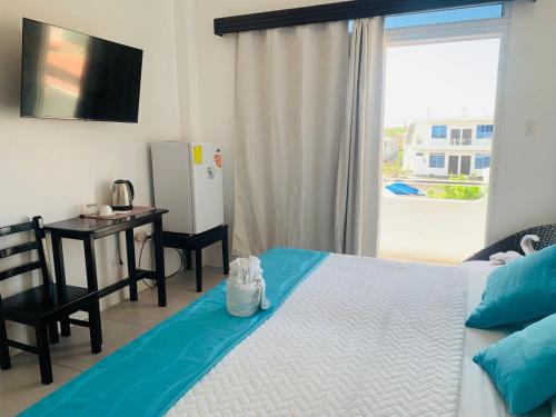 a bedroom with a bed and a desk and a window at Habitaciones privadas in Puerto Villamil