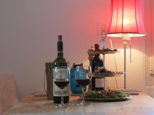 a bottle of wine and two glasses on a table at Chalet Safran in Grächen