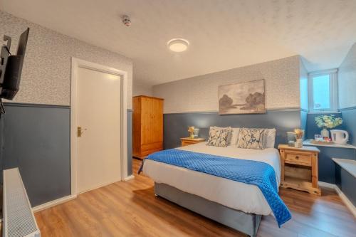 a bedroom with a bed with blue walls and a television at Castle Inn in Newtownstewart