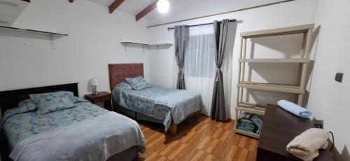 a bedroom with two beds and a mirror in it at Casa Ika Moana in Hanga Roa