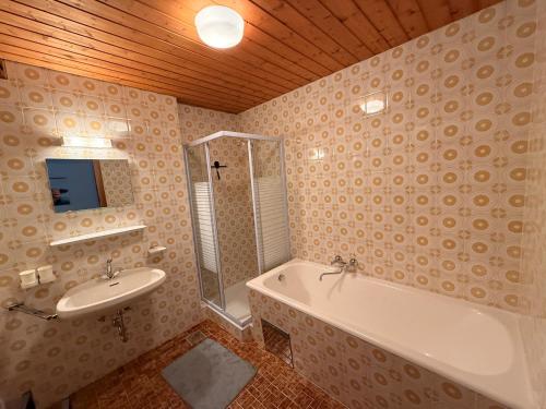 a bathroom with a sink and a bath tub and a sink at Haus Sauberbach in Jerzens