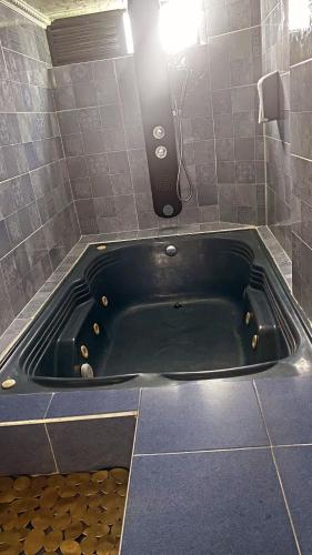 eine schwarze Badewanne in einem Badezimmer mit Licht in der Unterkunft Ecohotel Java in Manizales