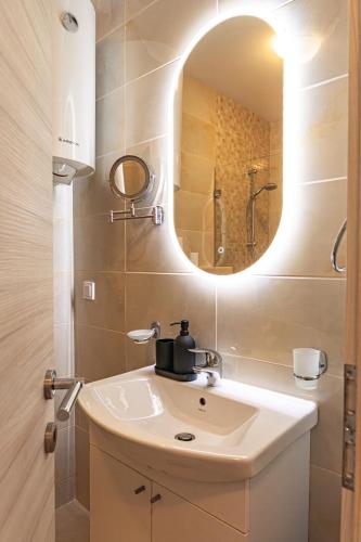 a bathroom with a sink and a mirror at Peace 2 Apartments with parking in Budva