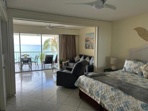 a bedroom with a bed and a view of the ocean at Oceanview large studio, pool, walk to Mullet Bay, Cupecoy Beach, walk to dining, free parking in Cupecoy