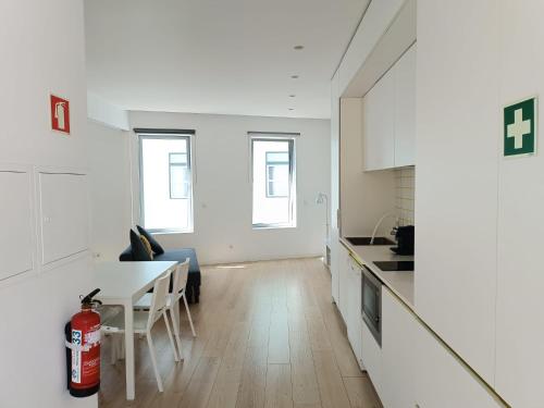 a kitchen and living room with a table and a fire extinguisher at Ria & Mar Collection I in Aveiro