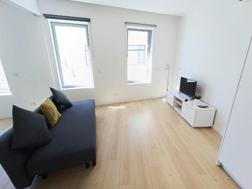 a living room with a black couch and a television at Ria & Mar Collection I in Aveiro