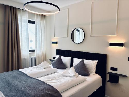 a bedroom with a bed with pillows and a mirror at Schwanstein Apartments Füssen ZENTRUM in Füssen