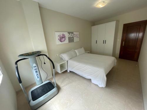 a small bedroom with a bed and a treadmill at A Riveira in Muxia