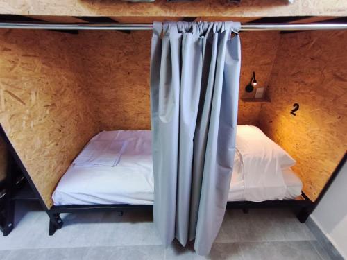 a room with two bunk beds and a curtain at Hostel Vila Universitária in Bauru