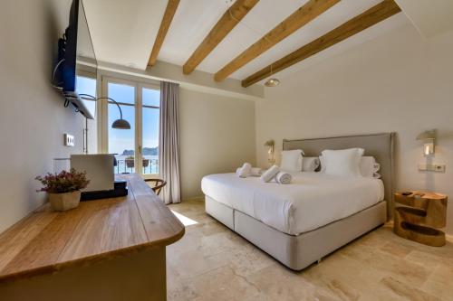 a bedroom with a large white bed and a television at Santa Barbara by Santas Hotels in Altea