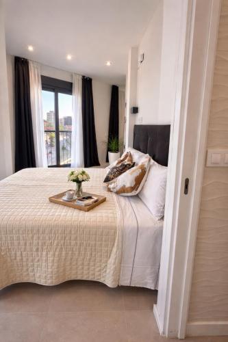 a bedroom with a bed with a tray of flowers on it at LUSAIL 1ª línea playa ADULTS ONLY in Vinarós