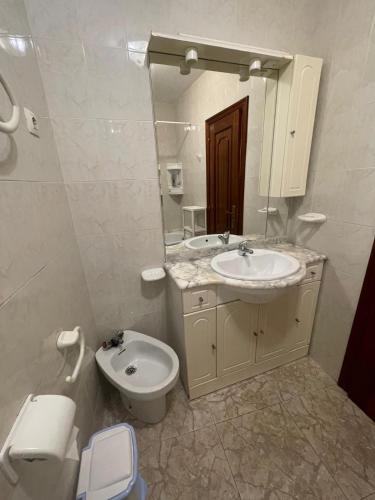 a bathroom with a sink and a toilet and a mirror at A Riveira in Muxia