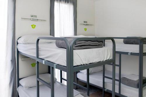 two bunk beds in a room with a window at Meeting Point Hostels in Barcelona
