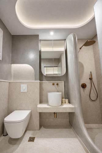 a small bathroom with a toilet and a sink at NOÈA Luxury Suites in Kavála